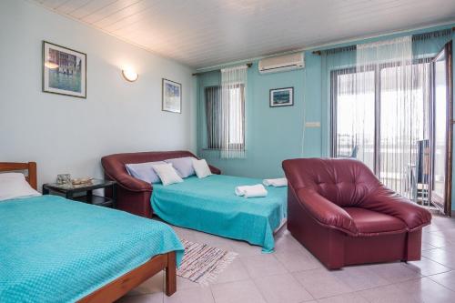 a bedroom with a bed and a couch and a chair at Apartment Nada in Vir