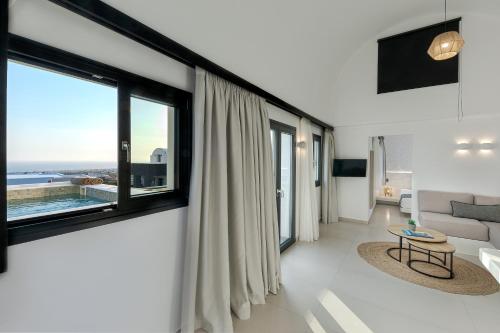 a living room with a large window and a couch at Onyx Hotel & Suites in Karterados