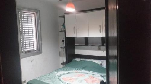 - une petite chambre avec un lit et une fenêtre dans l'établissement Sobrado Guaratuba Central, à Guaratuba