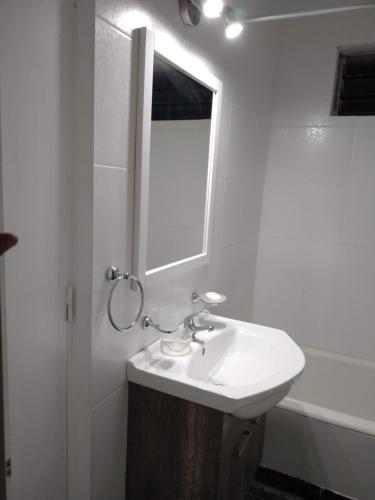 Baño blanco con lavabo y espejo en Dpto.2 habitaciones - 25 Mayo al 3000 en Mar del Plata