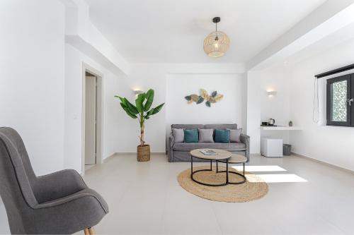 a white living room with a couch and a table at Onyx Hotel & Suites in Karterados