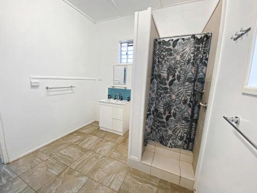 a bathroom with a shower with a black and white shower curtain at Warrego Hotel Motel Cunnamulla in Cunnamulla