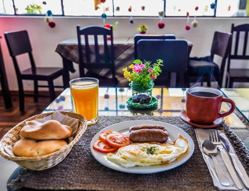 a table with a plate of breakfast food and drinks at Eco Home View - Guest House in Cusco