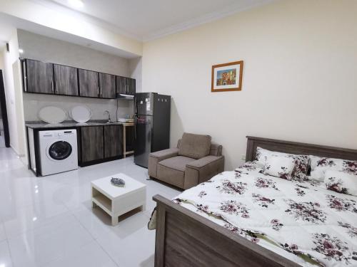 a bedroom with a bed and a chair in it at استوديو مفروش in Ajman 