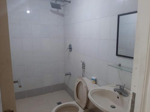 een badkamer met een toilet en een wastafel bij Family Staycation 2 with Pool in Manilla