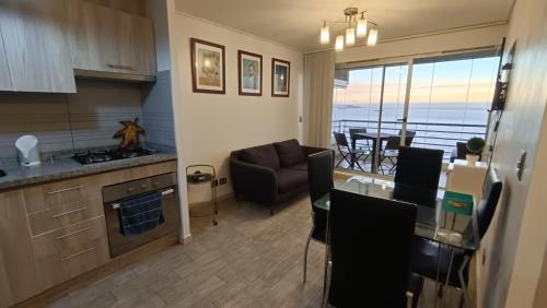 cocina y sala de estar con mesa y sofá en Luminoso Sector 5 - Reñaca en Viña del Mar