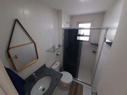 y baño con lavabo, espejo y aseo. en Apartamento completo en Manaus