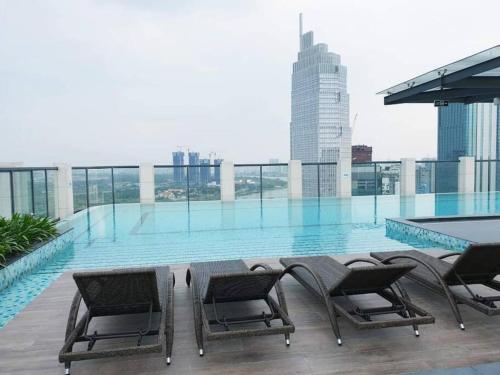 een zwembad met stoelen en een tafel op een gebouw bij The Rixx Boutique- Opera House- SmartTV65in - pool in Ho Chi Minh-stad