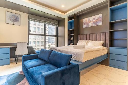 een slaapkamer met een bed en een blauwe bank bij The Rixx Boutique- Opera House- SmartTV65in - pool in Ho Chi Minh-stad