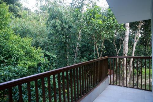 a balcony with a wooden railing and trees at Balishira Resort Ltd. in Sreemangal