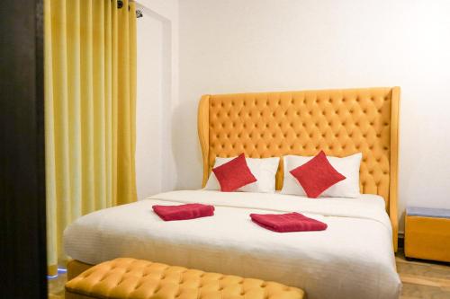 a bedroom with a large bed with red pillows at Vista Apartment Mariners Blue in Nuwara Eliya