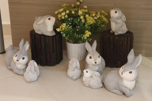 a group of rabbits and a vase with flowers at Big Orange Hotel Sungai Petani in Sungai Petani
