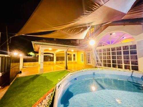 a house with a swimming pool at night at Trendy Family Getaway by StayCo - Mini-Pool, Outdoor Cinema, Air Loft, PS4, KTV - Just 2 mins to Beach! in Batu Ferringhi
