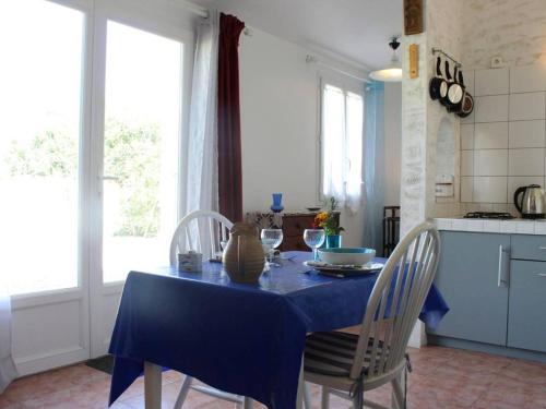 une cuisine avec une table et un chiffon bleu dans l'établissement Charmante maison oléronaise avec cour, proche plage et centre, 2 couchages, ménage inclus - FR-1-246A-371, à Dolus-d'Oléron