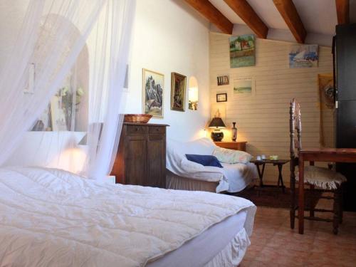 - une chambre avec deux lits, une chaise et une table dans l'établissement Charmante maison oléronaise avec cour, proche plage et centre, 2 couchages, ménage inclus - FR-1-246A-371, à Dolus-d'Oléron