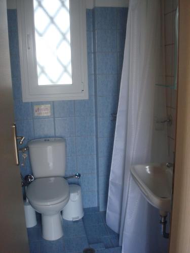 a bathroom with a toilet and a sink and a window at Aigaio Studios tinos in Tinos Town