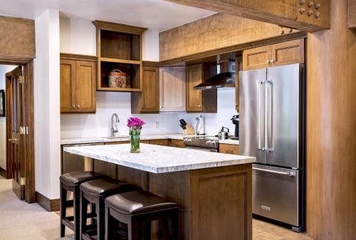 a kitchen with wooden cabinets and a stainless steel refrigerator at Luxury Three Bedroom Suite with Mountain Views and Three Hot Tubs apartment hotel in Park City