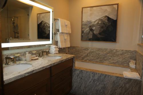 a bathroom with two sinks and a large mirror at Luxury Three Bedroom Suite with Mountain Views and Three Hot Tubs apartment hotel in Park City