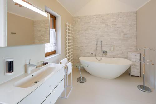 a bathroom with a large white tub and a sink at Hotel Château Cihelny in Karlovy Vary