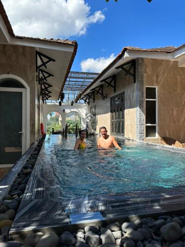 a man and a woman in a swimming pool at HELLO VILLA & SPA in Hue