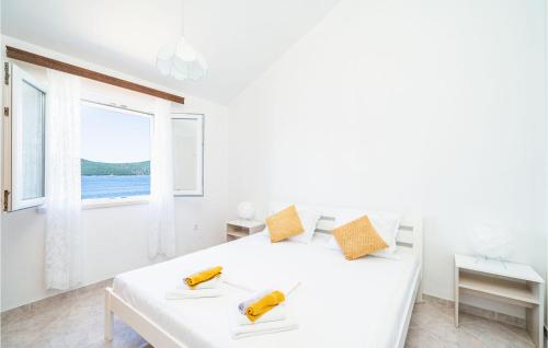 ein weißes Schlafzimmer mit einem Bett mit zwei Bananen drauf in der Unterkunft Gorgeous Home In Slano With House Sea View in Slano