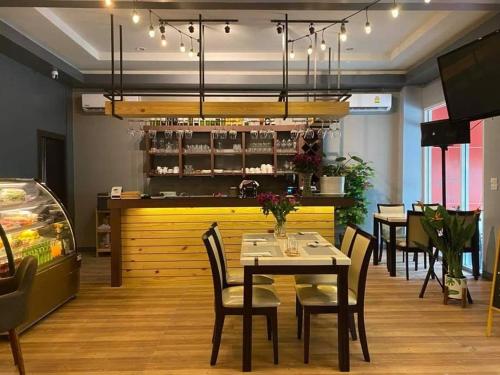 un restaurante con mesa y sillas y un bar en The Ring Residence en Hat Yai