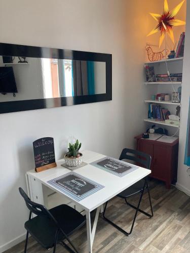 - une table et des chaises blanches dans la chambre dans l'établissement Cosy nest from 10 minutes PARIS centre, à Saint-Ouen