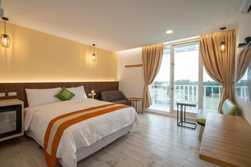 a hotel room with a bed and a large window at Kenting Shin Yu Homestay in Kenting