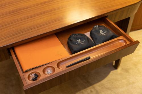 a wooden drawer with two black bags in it at Shenzhen Nanshan L'Hermitage in Shenzhen