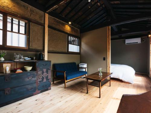 a bedroom with a bed and a table and a couch at Minamo in Ukiha