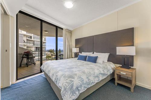 a bedroom with a large bed and a balcony at Grand Pacific Unit 112 Caloundra QLD in Caloundra