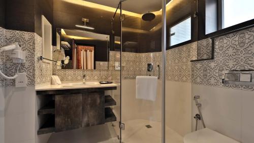 uma casa de banho com uma cabina de duche em vidro e um lavatório. em Soaltee Westend Resort Nagarkot em Nagarkot