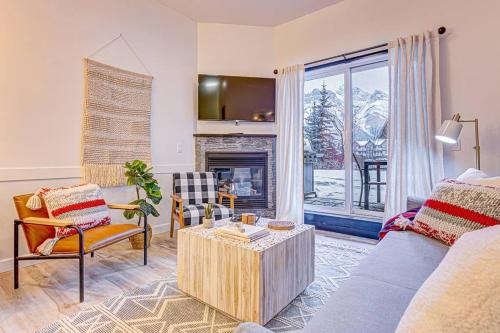 een woonkamer met een bank en een open haard bij Mountain Retreat, Pool & Hot Tub, BBQ, Patio, King Bed, Sleeps 6! in Canmore