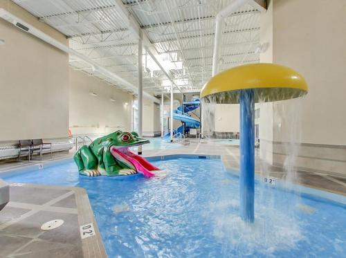 una piscina con un dinosaurio de plástico en un parque acuático en Mountain Retreat, Pool & Hot Tub, BBQ, Patio, King Bed, Sleeps 6! en Canmore