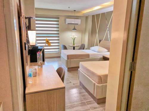 a hotel room with two beds and a living room at New Dawn Plus in Cagayan de Oro