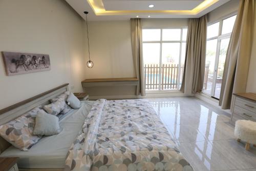 a bedroom with a large bed in a room with windows at منتجعات روزا بارك in Ad Dawādimī