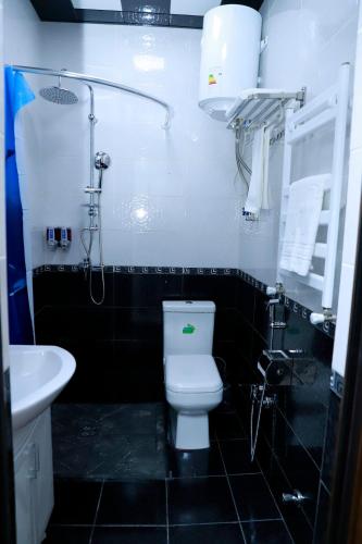 a bathroom with a toilet and a sink at RamRamay in Qax
