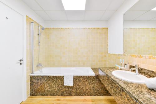 y baño con bañera y lavamanos. en Luxury JBR · 2BR · 5* Beach Resorts Access!, en Dubái