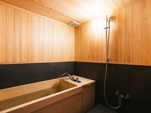 a bathroom with a sink and a bath tub at Minamo in Ukiha
