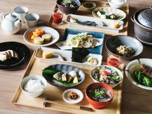 einem Holztisch mit Teller mit Lebensmitteln darauf in der Unterkunft Minamo in Ukiha