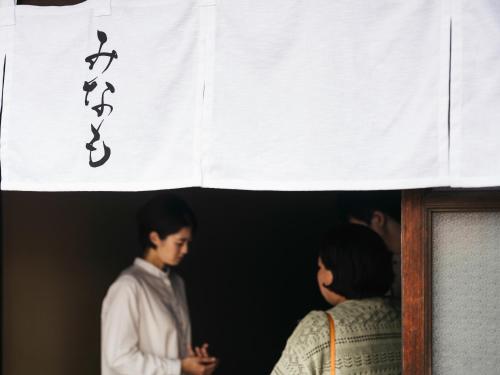 a man and a woman standing under a banner with writing on it at Minamo in Ukiha