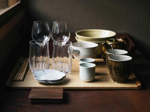 a tray with wine glasses and bowls on a table at Minamo in Ukiha