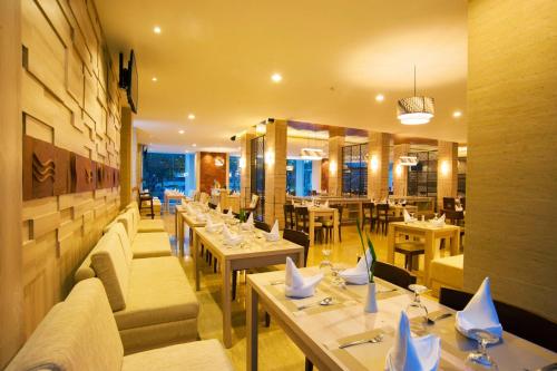 restauracja ze stołami i kanapami w pokoju w obiekcie Lombok Raya Hotel w mieście Mataram