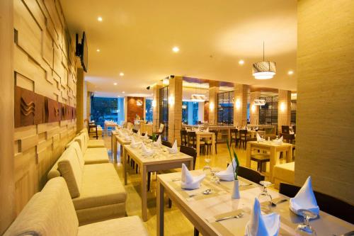 a restaurant with tables and couches in a room at Lombok Raya Hotel in Mataram