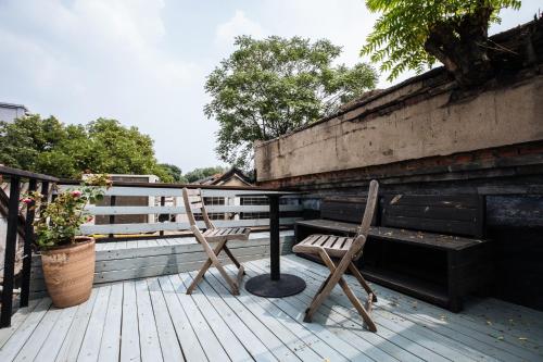a pair of chairs sitting on a wooden deck at The Orchid Hotel - Old Town & Drum Tower in Beijing