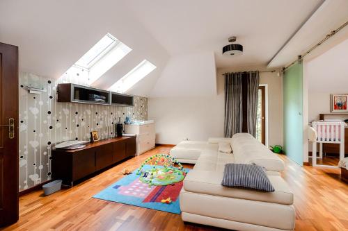 a living room with a white couch and a kitchen at Luxury Villa Pool and Spa in Magdalenka