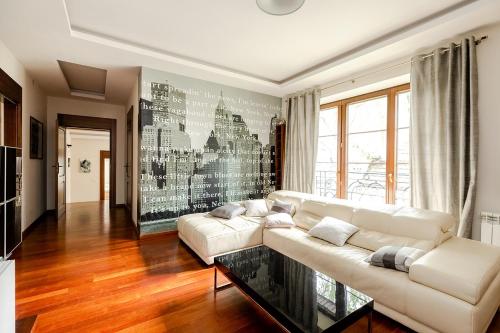 a living room with a white couch and a glass table at Luxury Villa Pool and Spa in Magdalenka