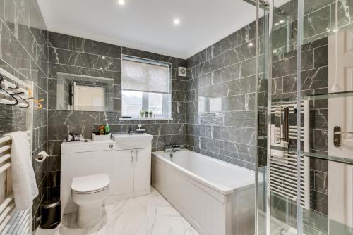 a bathroom with a tub and a toilet and a sink at Bright & Spacious 2-Bedroom Jericho House in Oxford