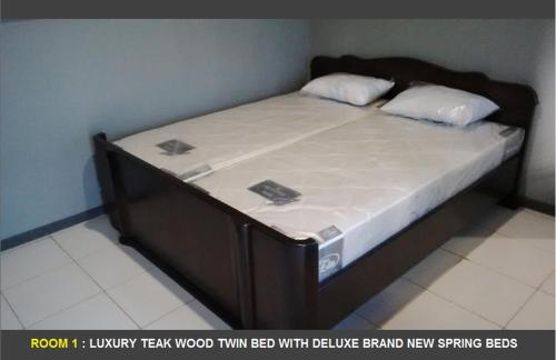 a large bed with a wooden frame in a room at CIDERES HOLIDAY HOME in Majalengka