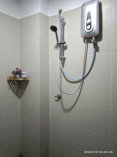 a shower in a bathroom with a hose at Armada Sweet Homestay in Gua Musang